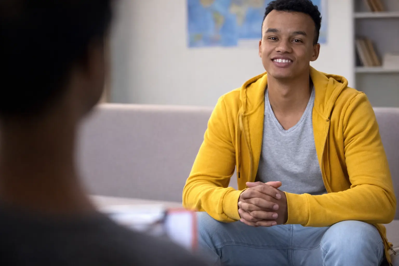 Vrouw zit bezorgd aan tafel en bespreekt hulp voor haar partner